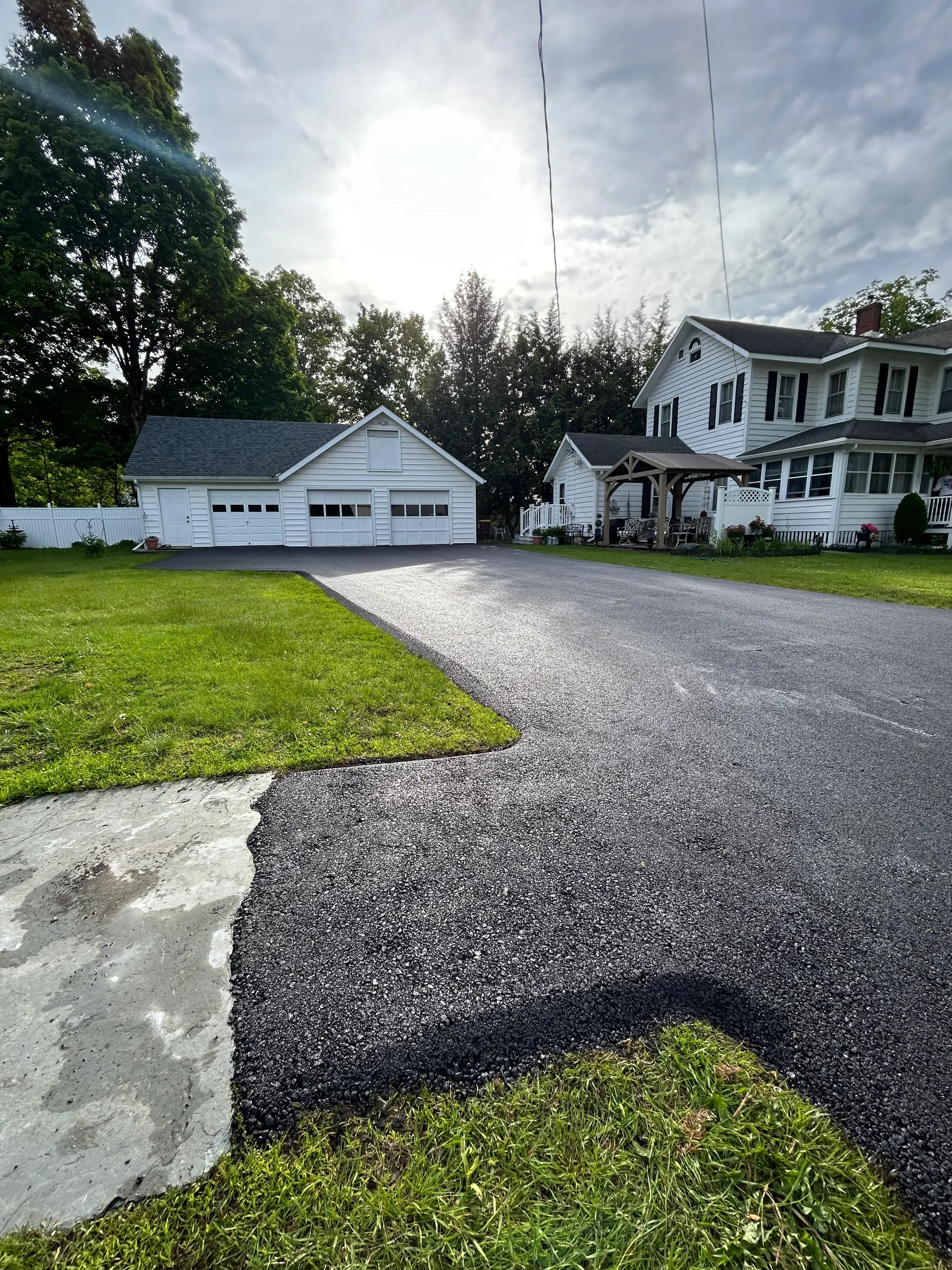New asphalt driveway with concrete edge and lawn borders