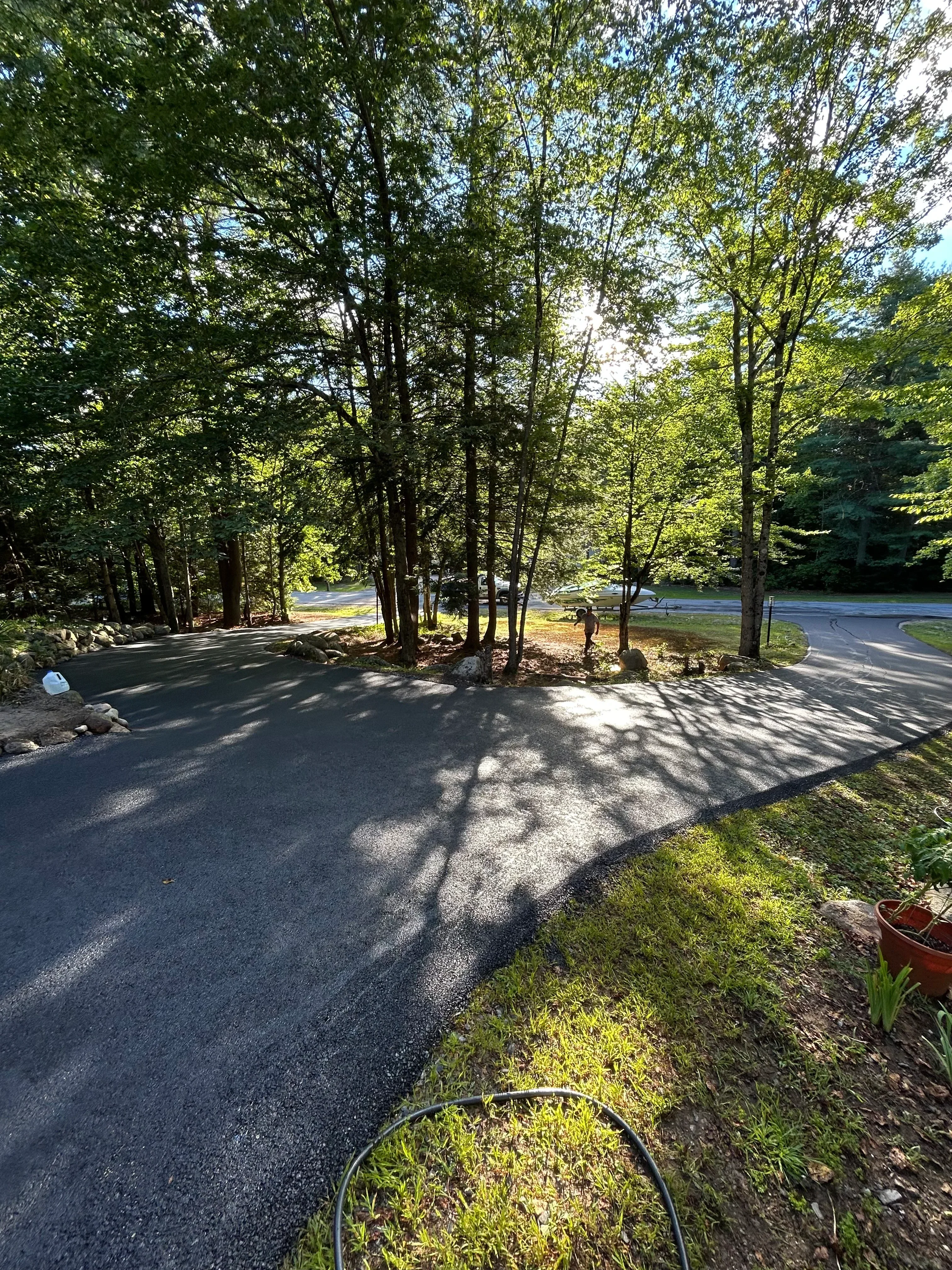 Newly installed asphalt driveway with dark aggregate surface and clean edges