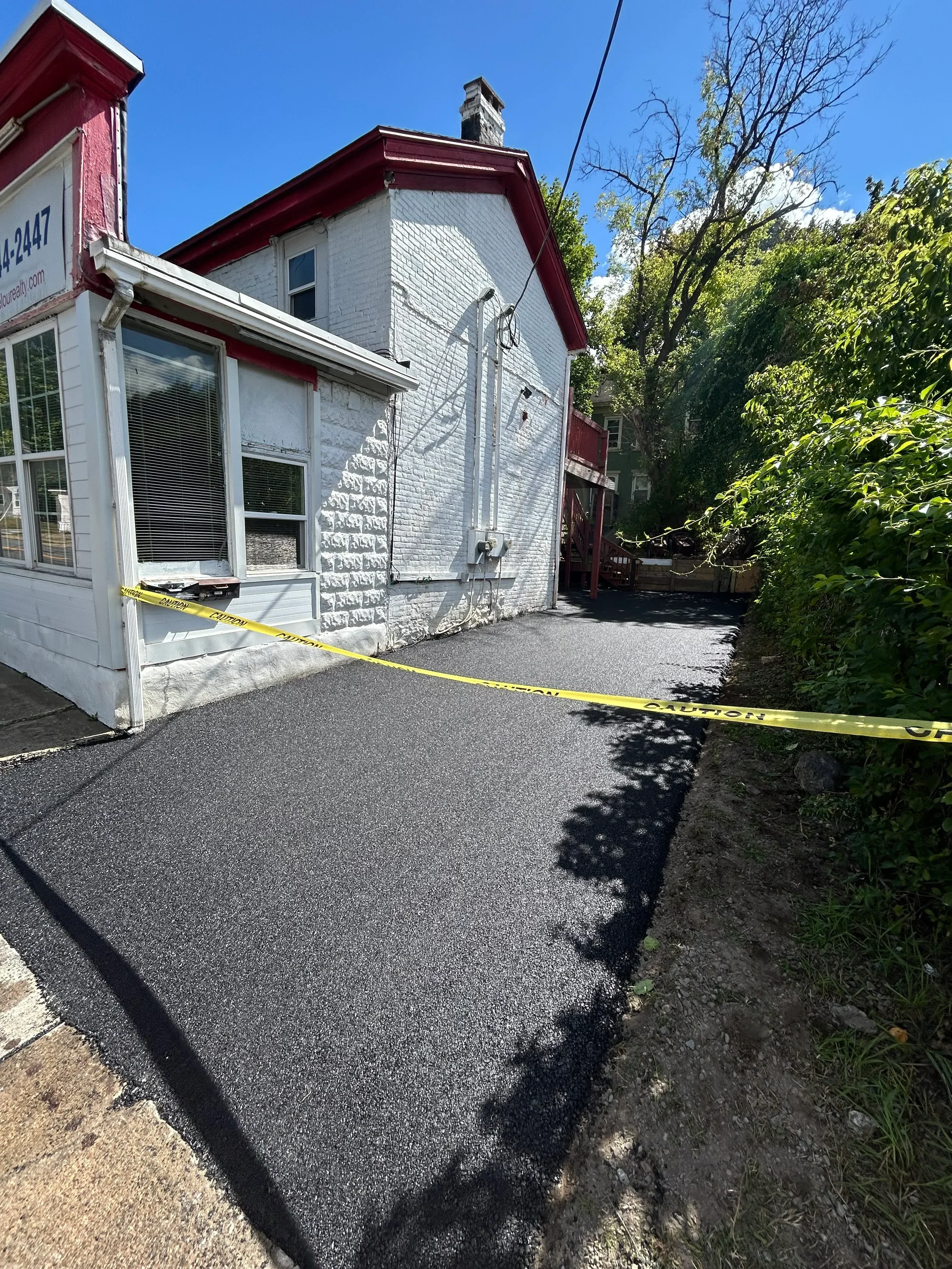 New asphalt driveway with dark pavement and proper slope for drainage