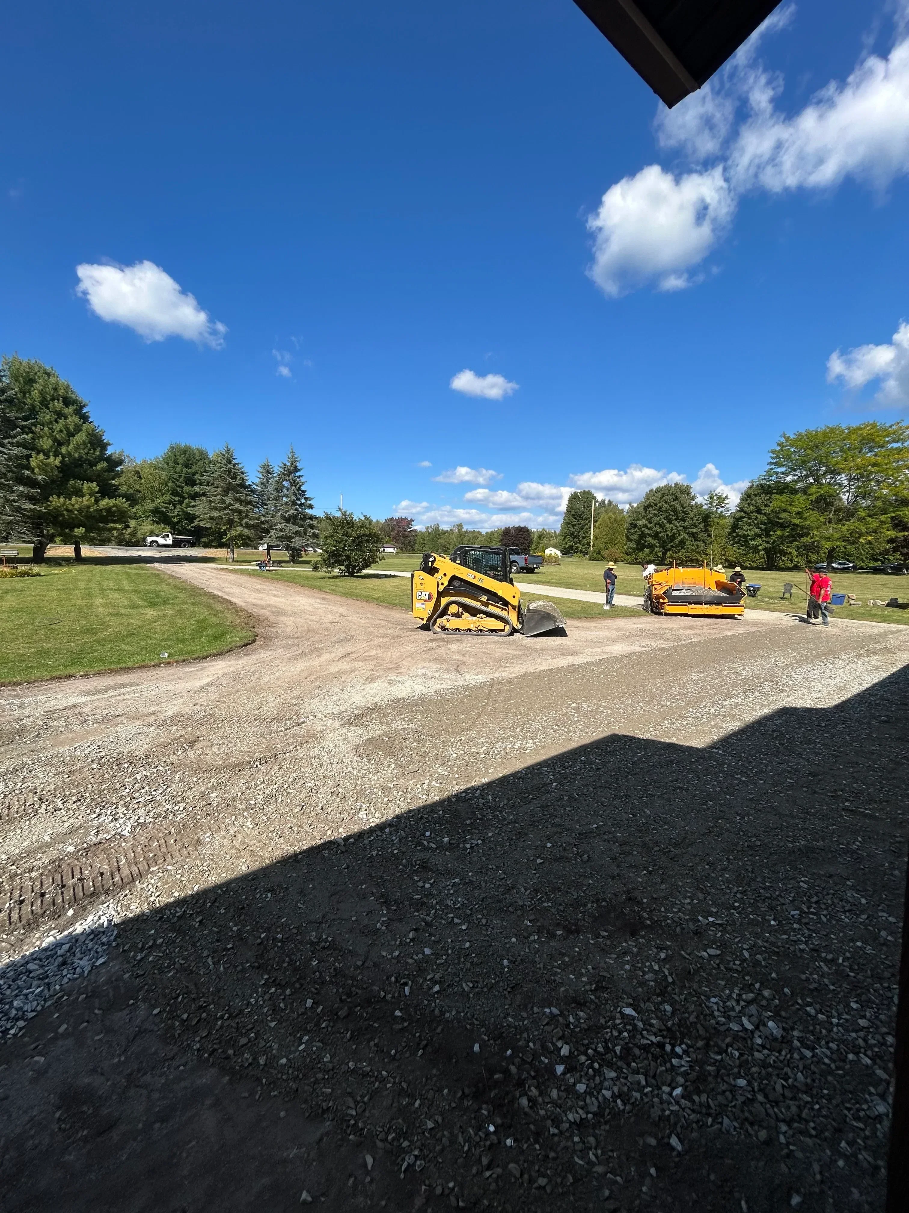 Asphalt driveway installation with compaction rollers and fresh asphalt material
