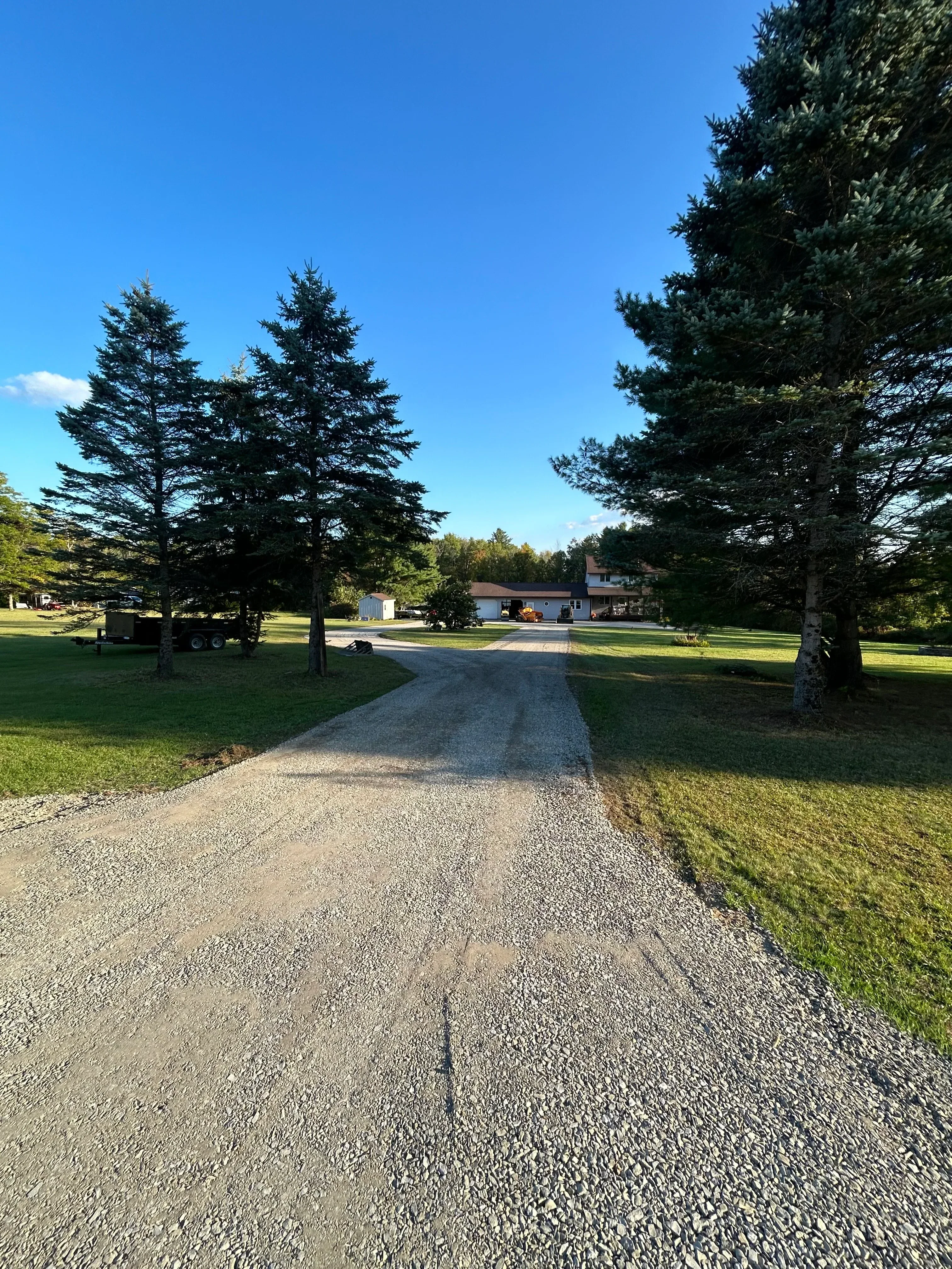 Newly installed asphalt driveway with clean edges and proper grading next to lawn